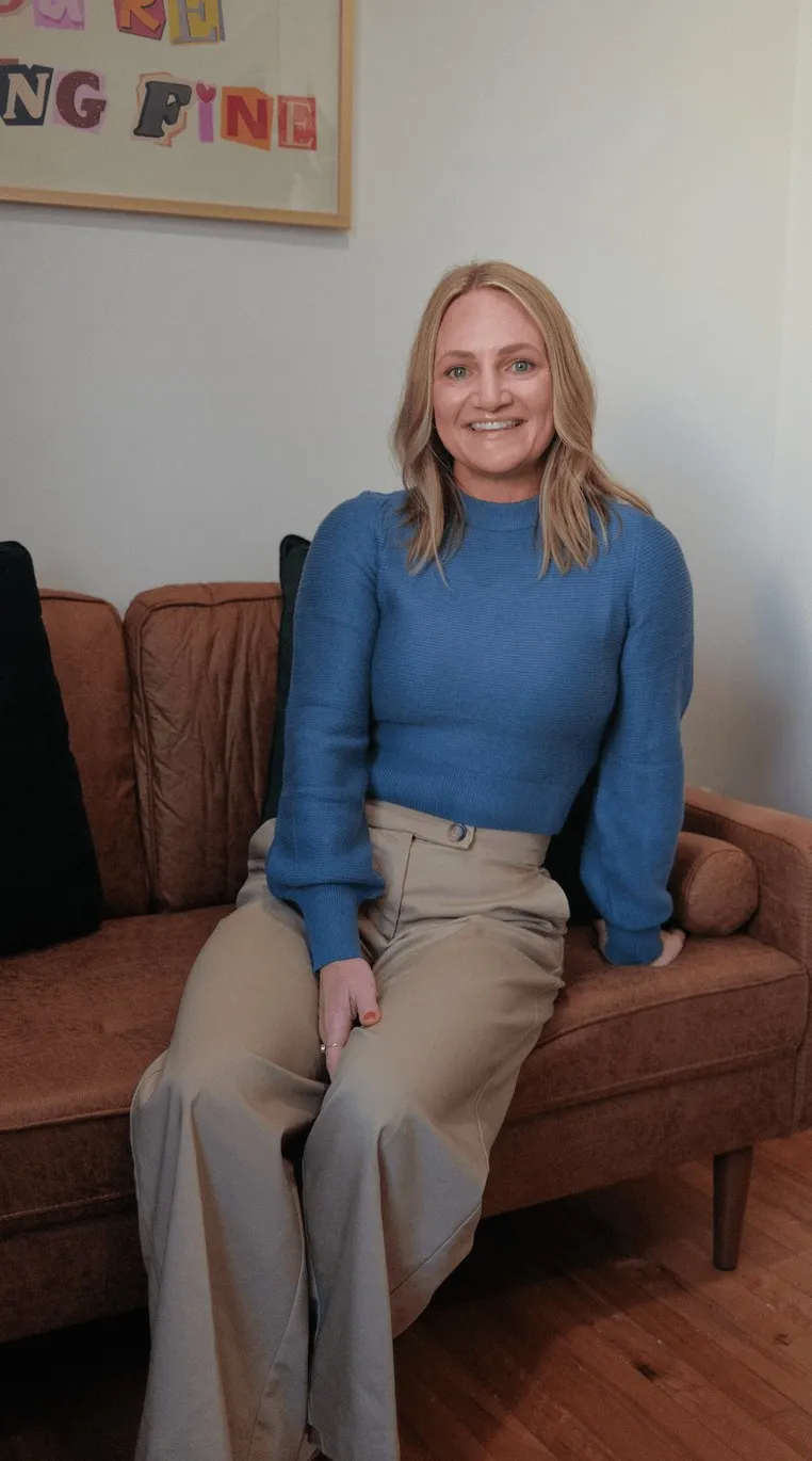 Brittany sitting on a sofa in the studio